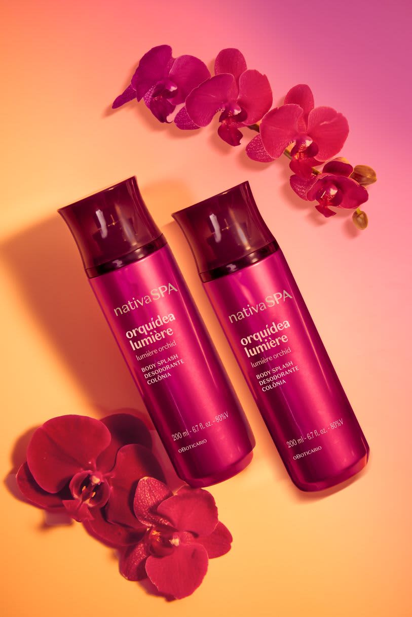 Dois frascos de Body Splash Nativa SPA Orquídea Lumière e flores de orquídea roxas, representando frescor e perfumação leve