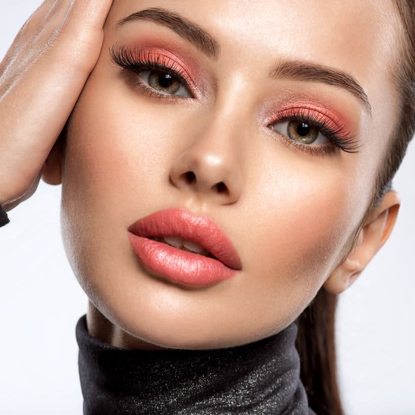 Mulher usando maquiagem rosa em tons claros