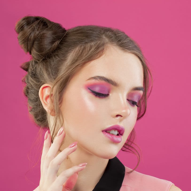 Mulher usando maquiagem rosa com sombra e delineado