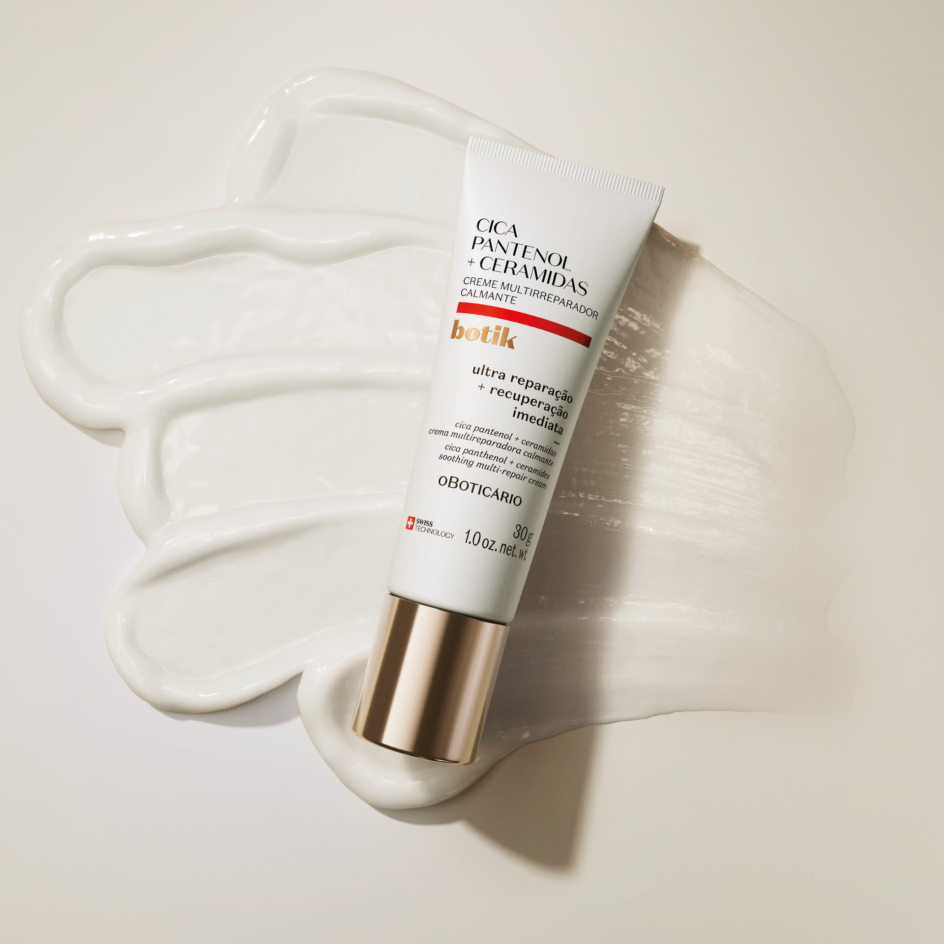 Tubo do Creme Multirreparador Calmante Botik Cica Pantenol + Ceramidas deitado sobre uma camada de produto cremoso branco.