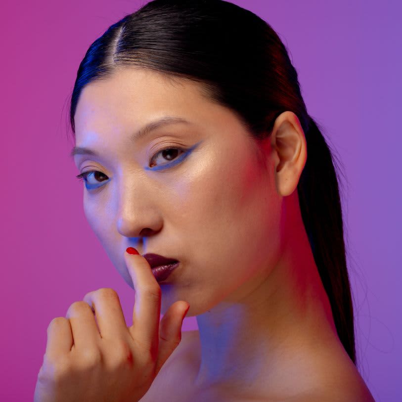 Mulher asiática usando maquiagem com delineado azul