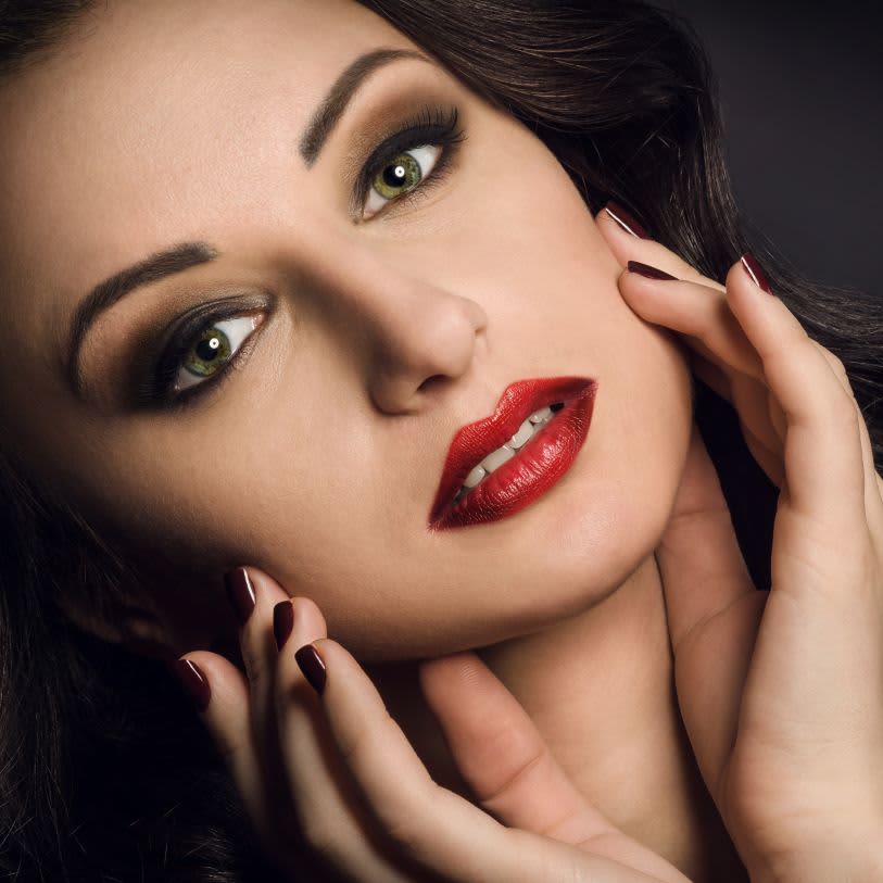 Mulher maquiada com olhos esfumados e batom vermelho