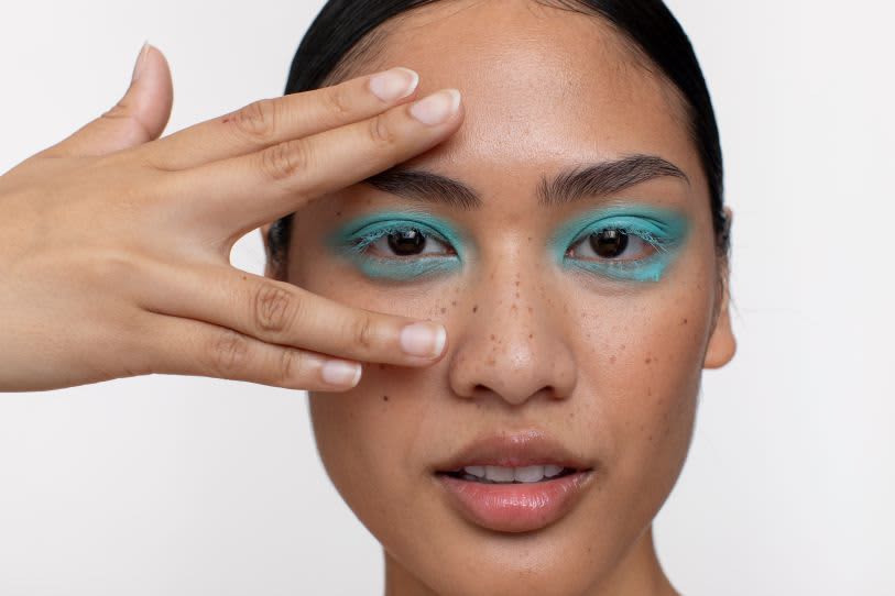 Mulher com olhos maquiados com sombra azul