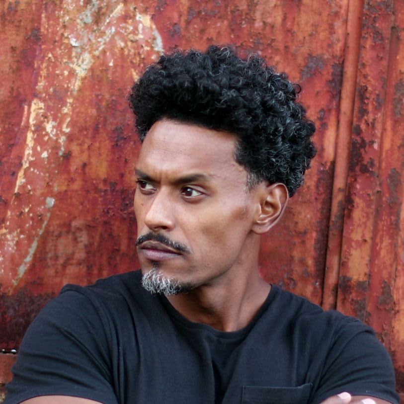 Homem com cabelo crespo e barba com bigode e cavanhaque