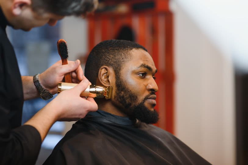 Homem realizando corte em barbearia