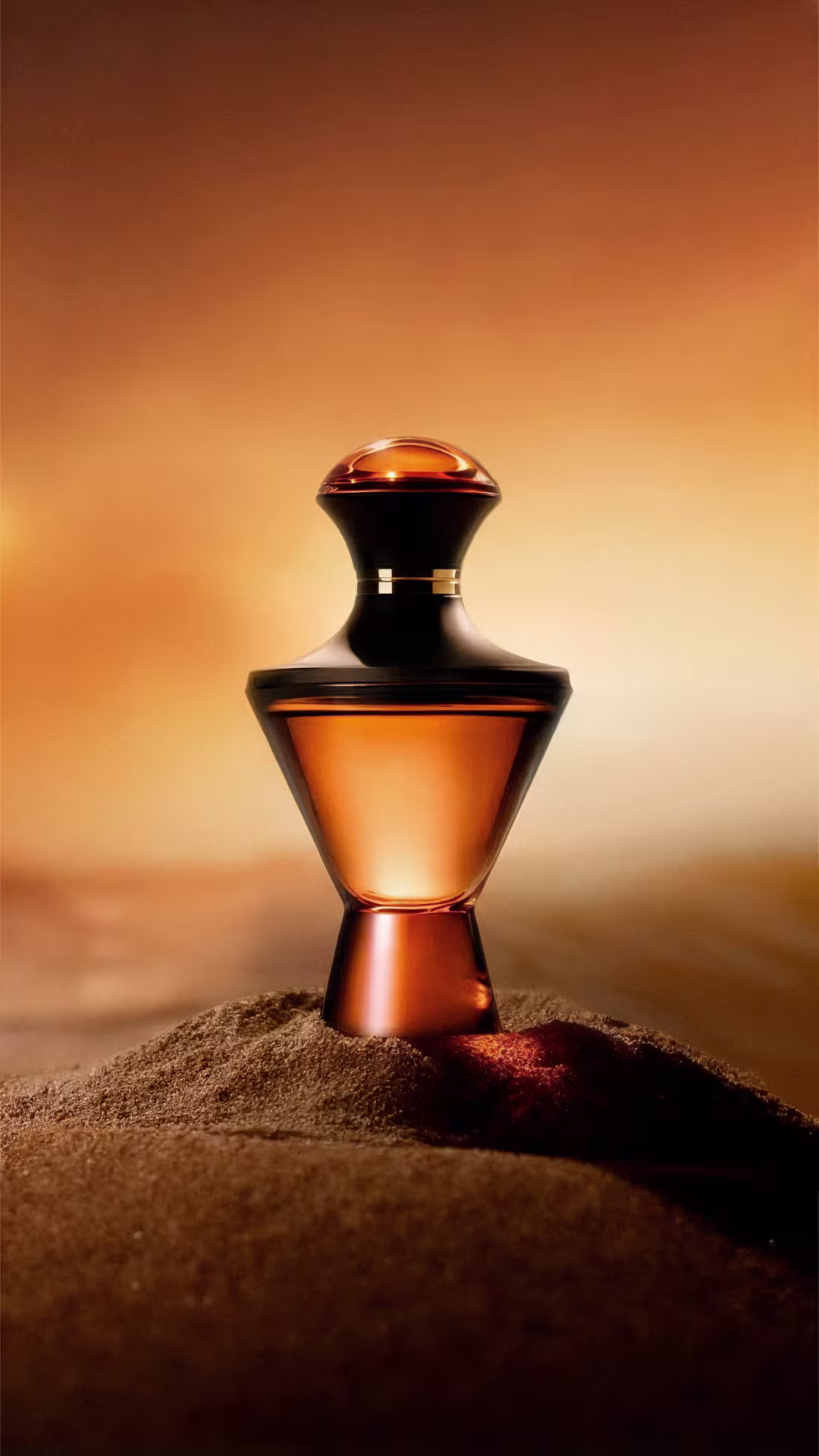 Frasco da fragrância Hadiya posicionado em um chão com areia