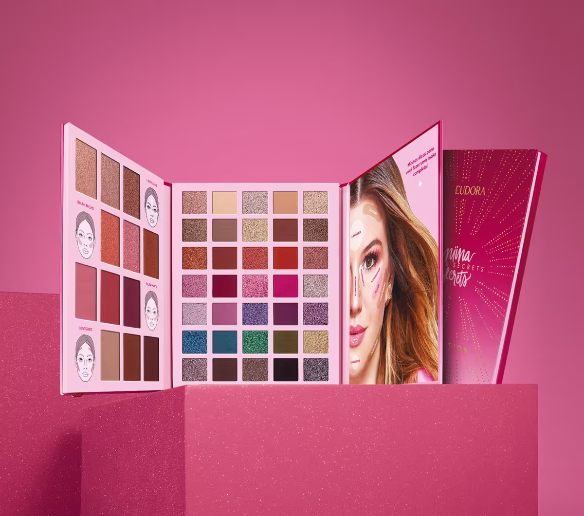 Paleta Celebration Niina Secrets em um podium rosa com fundo rosa. A paleta está aberta mostrando todas as cores de sombras, contornos, iluminadores e blushes.
