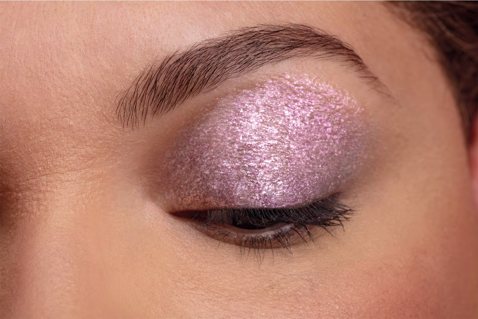 Foto com foco no olho da modelo com o glitter para olhos