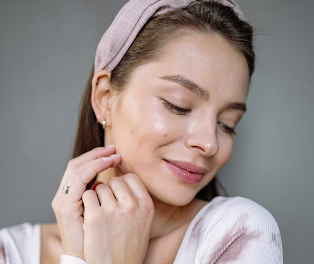 Mulher com o rosto limpo que passa a sensação de renovação da pele após o skincare feito.