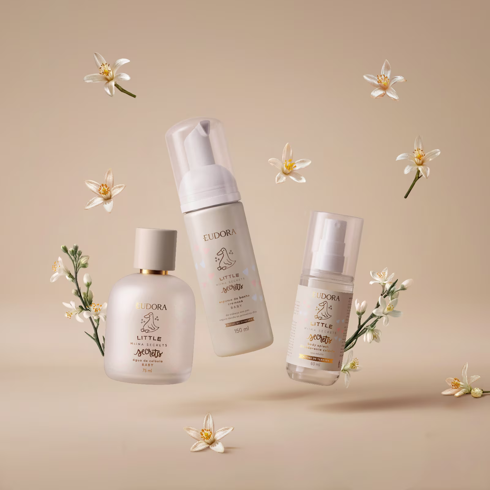 Produtos da linha Eudora Little Niina Secrets Baby flutuando entre flores brancas em fundo bege. Estética suave, clean e delicada.