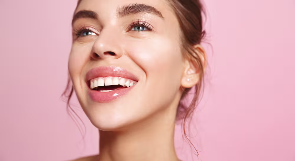 Maquiagem com pele iluminada, gloss nos lábios e acabamento natural