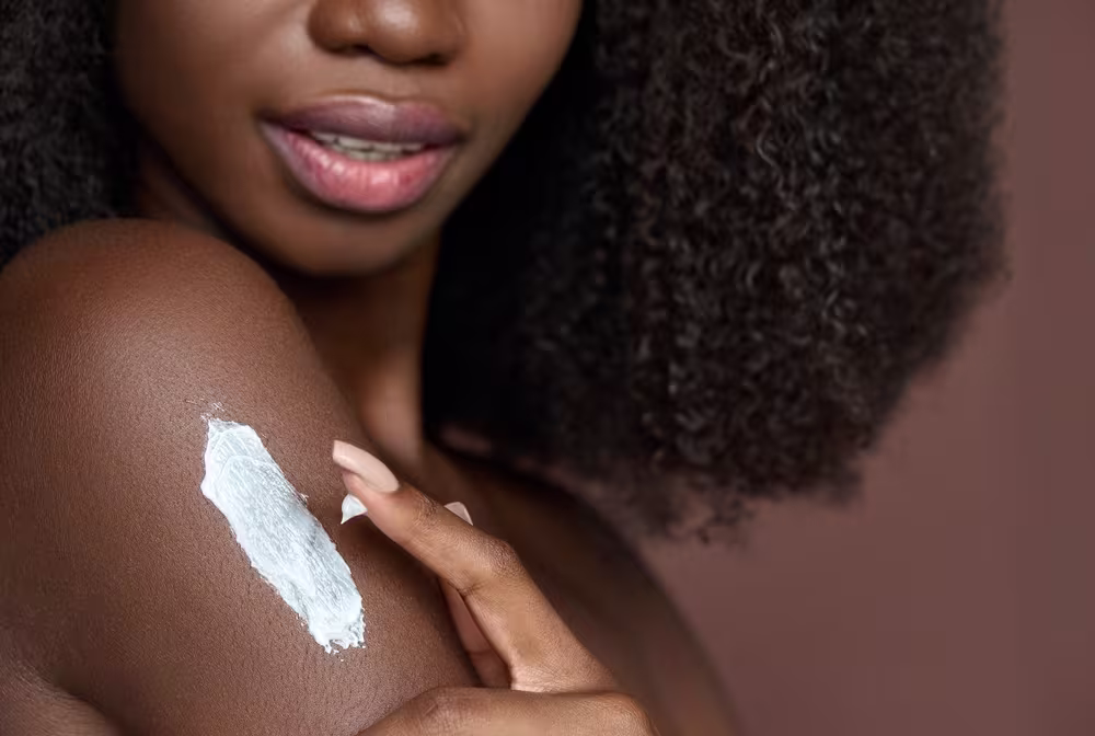 Imagem de mulher aplicando creme hidratante na pele