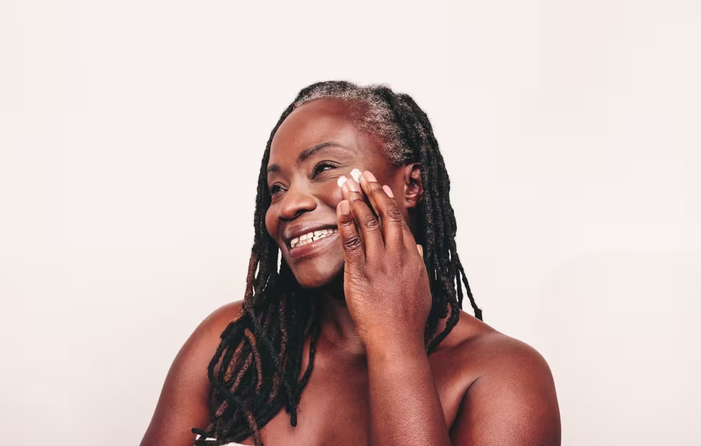 Imagem de mulher aplicando produto de beleza na pele