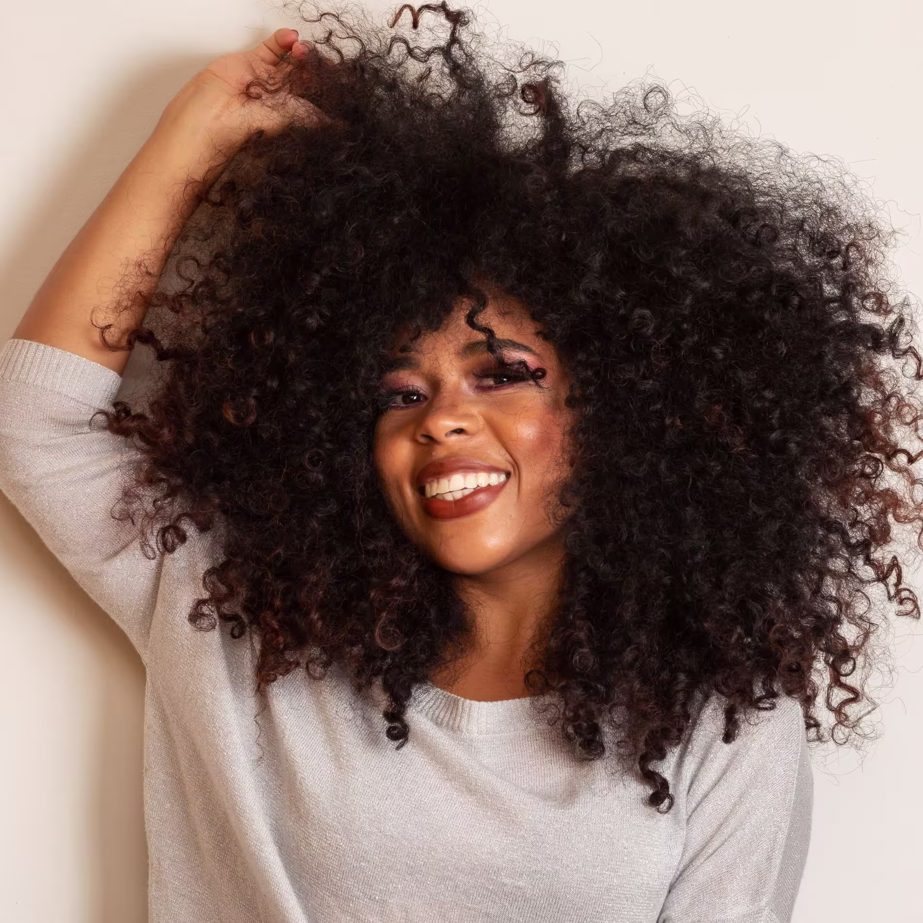 Mulher de cabelo cacheado e volumoso