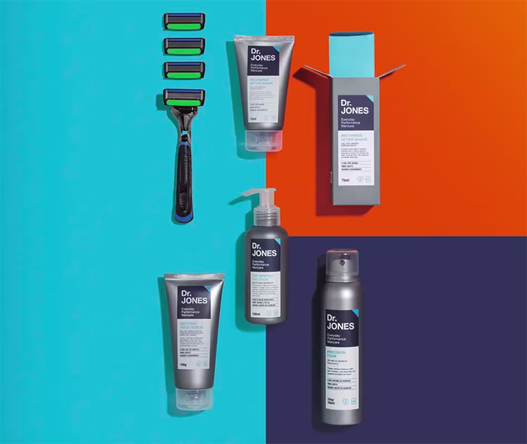 Em fundo azul, vermelho e roxo, fotos dos produtos da Linha Barba e Rosto da Dr. JONES e do aparelho de barbear The Razor6.