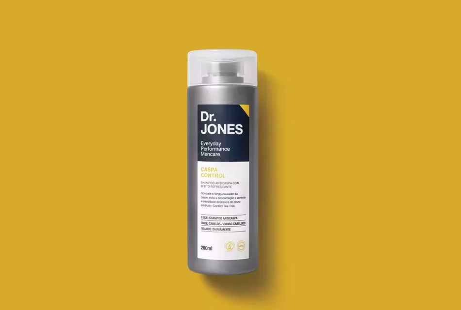 Foto do shampoo anticaspa CASPA CONTROL, da Dr. JONES, que tem climbazol na fórmula. Na imagem, em fundo amarelo, vê-se a embalagem do produto em destaque.