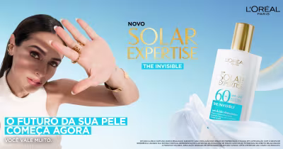 O banner mostra duas mulheres jovens e bonitas, uma de cabelos cacheados e outra de cabelos lisos, promovendo um protetor solar da L'Oréal para prevenir o fotoenvelhecimento da pele.