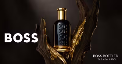 Banner publicitário para perfume Boss Bottled, mostrando frasco preto e dourado em destaque sobre fundo escuro.