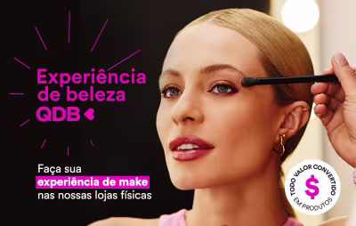 O banner mostra uma mulher sendo maquiada por uma consultora em loja, na experiência de beleza QDB.