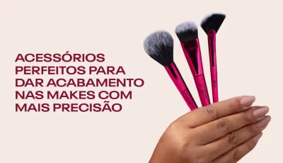 Uma mão segurando três pincéis de maquiagem de cor rosa. Acessórios perfeitos para dar acabamento nas makes com mais precisão.