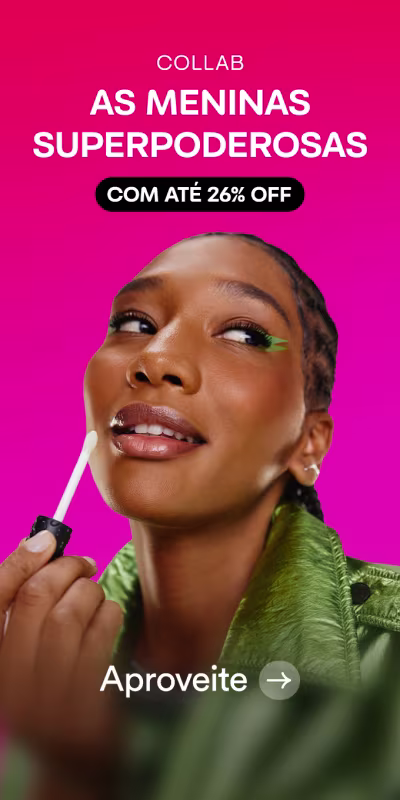 Mulher negra com maquiagem verde, segurando pincel de gloss na mão, comunicando a collab As Meninas Superpoderosas com até 26% de desconto, sobre fundo rosa vibrante.