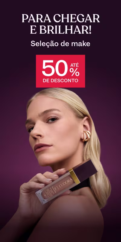 Mulher loira segurando um frasco da Base Skin Perfection, sobre fundo roxo, comunicando seleção de make com até 50% de desconto.