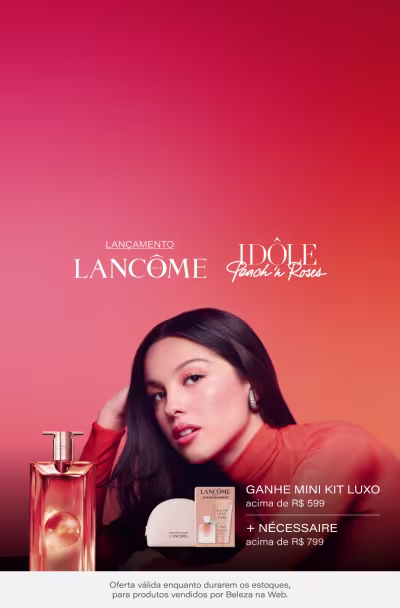 Uma mulher de cabelos escuros vestida com roupas vermelhas em um fundo laranja e vermelho. A imagem promove um lançamento da marca Lancôme, incluindo um mini kit de luxo e o perfume Idole Peach 'n Roses.