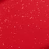 A imagem mostra a tampa da embalagem de balm, semelhante a uma tampa de batom, transparente e cilíndrica. Ao lado, a embalagem do balm, com o produto de cor coral com a palavra KIND escrito na embalagem.