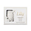 Conjunto de sabonetes em barra perfumados Lily. Rótulo com o nome "Lily" em letras douradas e descrição do produto. Imagem em relevo de um sabonete com detalhes florais esculpidos. Cores predominantes são branco, dourado e cinza claro.
