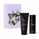 Kit de produtos de beleza da marca Her Code, incluindo um frasco preto de Splash e um tubo preto de Loção Hidratante Corporal, apresentados em uma caixa decorada com flores coloridas.