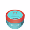 A imagem mostra a Máscara Capilar Moroccanoil Repair 250ml, um pote redondo de plástico na cor azul turquesa com detalhes em laranja. As informações sobre o produto estão escritas em inglês e espanhol no rótulo do pote.