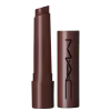 A imagem mostra uma embalagem de balm labial, cilíndrica, toda marrom escuro, com a tampa ao lado, também toda marrom escura com a logo da marca MAC, escrito em preto. Tem um pouco do balm, também marrom escuro, à mostra.