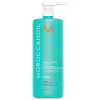 A imagem mostra o Shampoo Moroccanoil Repair Moisture 1L, um frasco de plástico azul turquesa e com uma bomba dosadora branca na parte superior. O logo traz um M em tom de laranja e o nome da marca em branco.