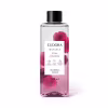 O produto apresentado é um óleo bifásico corporal da linha Instance Rosa Absoluta. O frasco é transparente, com um rótulo branco contendo o nome da marca, da linha e do aroma. A embalagem possui uma tampa preta e contém 200 ml do produto.