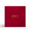 Caixa retangular de cor vermelha com textura de malha. Apresenta as iniciais "O.U.I" em letras douradas. A embalagem tem um design minimalista e elegante.