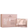 O produto apresentado é um tratamento capilar para cabelos loiros da linha Schwarzkopf Professional. Há uma caixa retangular de cor bege claro com o nome "Blondme All Blondes Vitamin C Shot" em letras brancas e cinzas. Os sachês são de cor bege claro