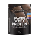 Proteína em pó da marca Puravida de 450g . O nome do produto "Grassfed Whey Protein" está escrito em letras grandes brancas, indicando que é uma proteína de soro de leite de gado alimentado com grama. O sabor é chocolate belga.