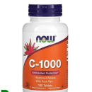 Este é um suplemento alimentar da marca Now Foods, com embalagem branca e tampa azul. O rótulo laranja destaca C-1000 Antioxidant Protection. O logotipo da Now Foods com uma flor estilizada está presente. As cores predominantes são branco, laranja e azul