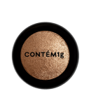 A imagem mostra uma embalagem de pó iluminador cor dourada e no centro, a logo da marca em preto.