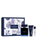 A imagem mostra um conjunto de produtos de perfumaria Narciso Rodriguez. Inclui um frasco azul escuro do perfume, uma caixa de presente com estampa floral azul e branca, um tubo de creme para o corpo e um frasco de perfume em miniatura.