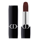 A imagem mostra uma embalagem de balm labial, tipo bala, vinho, com a tampa ao lado. A embalagem é preta e prata com o logo da marca em prata.