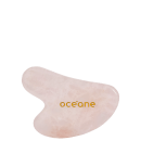 Gua sha em quartzo rosa com a logo da marca em letras douradas.