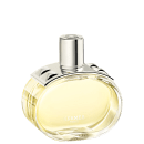 A imagem mostra o perfume Barénia de Hermès. Seu frasco é de vidro arredondado e transparente, permitindo ver o líquido amarelado em seu interior. Sua tampa é cilíndrica e prateada e possui uma aplicação com pinos em forma de pirâmide com facetas curvas.