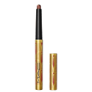 A imagem mostra uma sombra em bastão, em embalagem dourada, com detalhes vermelhos e logo da marca em preto. Ela está aberta, com a tampa ao lado.