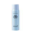 A imagem mostra o produto Keune Get a Grip. Embalagem cilíndrica azul claro. Nome do produto "Get a Grip Dry texturizer spray" e logotipo da Keune em letras pretas.
