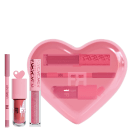 Conjunto de glosses labiais e lápis apontável da marca Fran by Franciny Ehlke, incluindo  um estojo em formato de coração rosa com detalhes em rosa e branco.