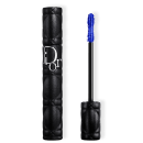 Embalagem preta em formato cilíndrico com textura de couro, com logotipo "Dior" em branco. Ao lado, um aplicador de máscara de cílios com textura de cor azul com cerdas ríspidas.
