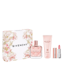Conjunto de produtos de beleza da marca Givenchy, incluindo um frasco de perfume Irresistible, um tubo de creme corporal e um batom rosa, todos embalados em uma caixa decorada com flores em tons de rosa e prateado.