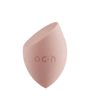 Esponjas de maquiagem, com formato assimétrico e textura macia, com o logotipo "O.C.N." impresso na superfície.