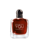 Frasco  e caixa do perfume com formato esférico e tampa prateada. O líquido vermelho exibe o texto "STRONGER WITH YOU POWERFULLY" em letras brancas. O produto é apresentado em fundo preto, destacando sua aparência elegante e sofisticada.